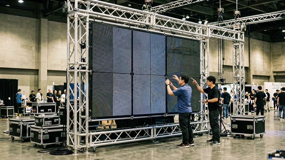 Rental LED screen built from modular panels with rigging backstage at an exhibition hall, controlled by Huidu hardware