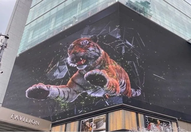 Naked eye 3D LED billboard displaying a tiger 3D animation on the side of a building