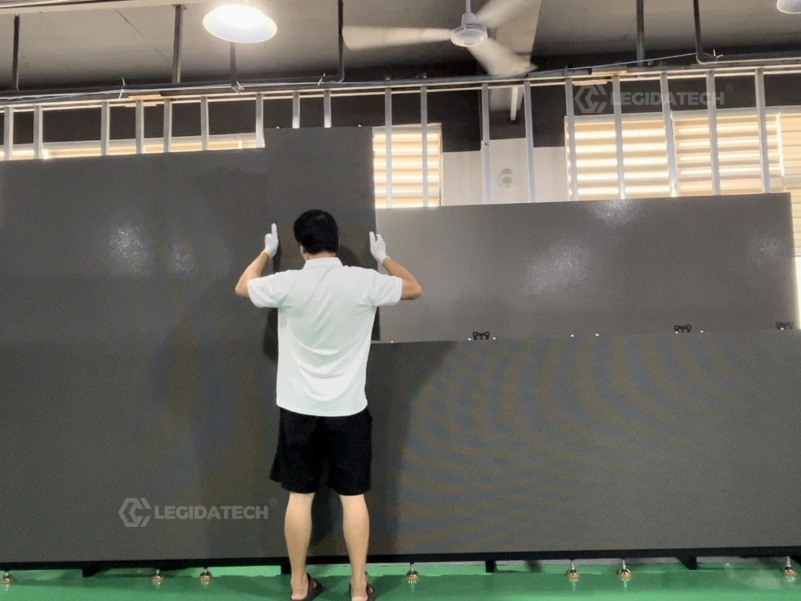 Two technicians building an AF1000 500x1000mm rental LED display wall with fewer cabinets per square meter