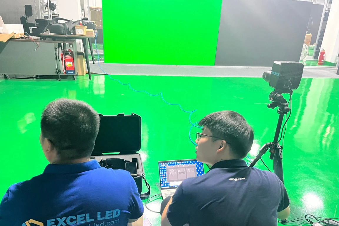 Technicians calibrating a P1.5 COB LED screen on site with a colorimeter camera